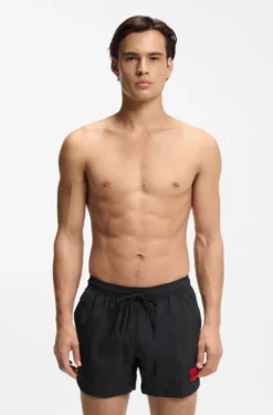 Quick-drying swim shorts with red logo label