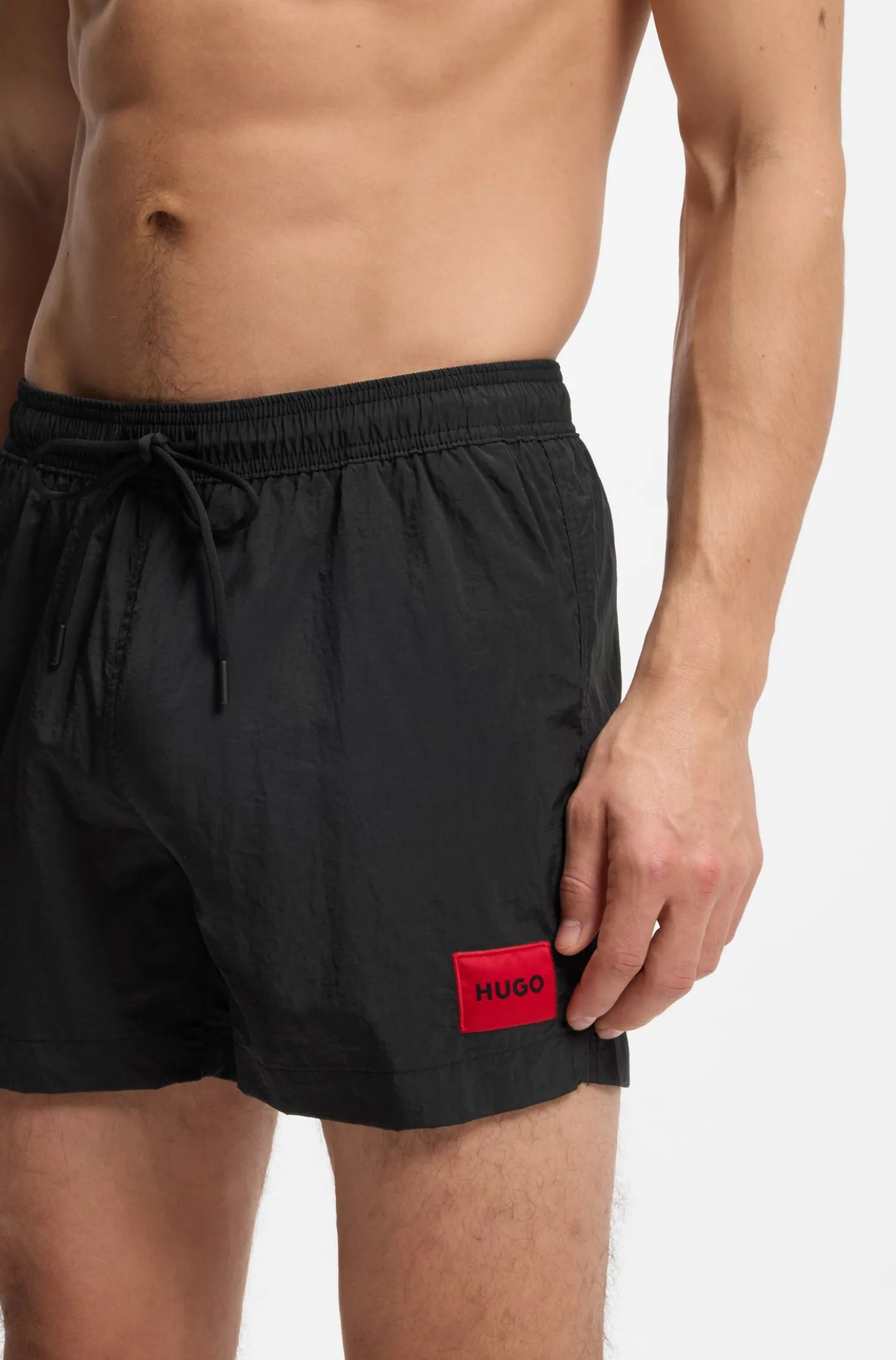 Quick-drying swim shorts with red logo label
